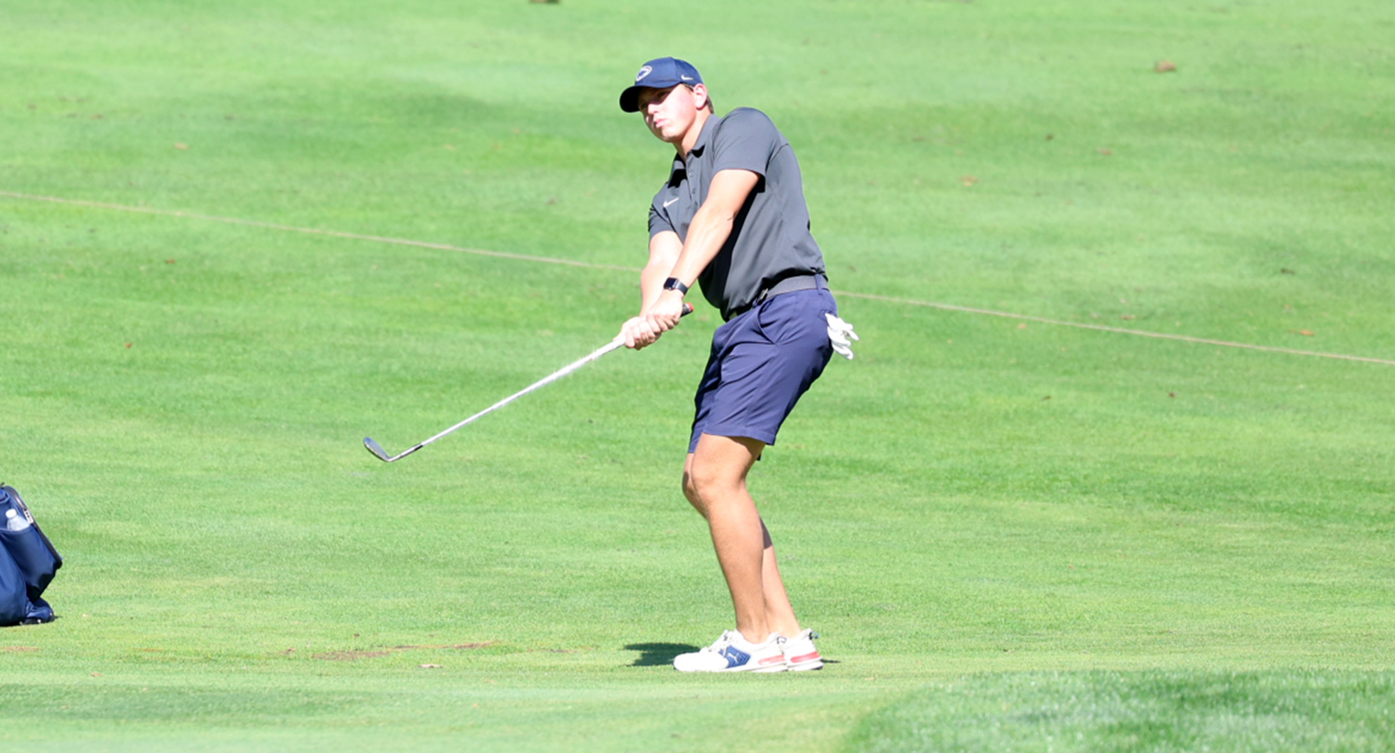 male golfer swinging iron
