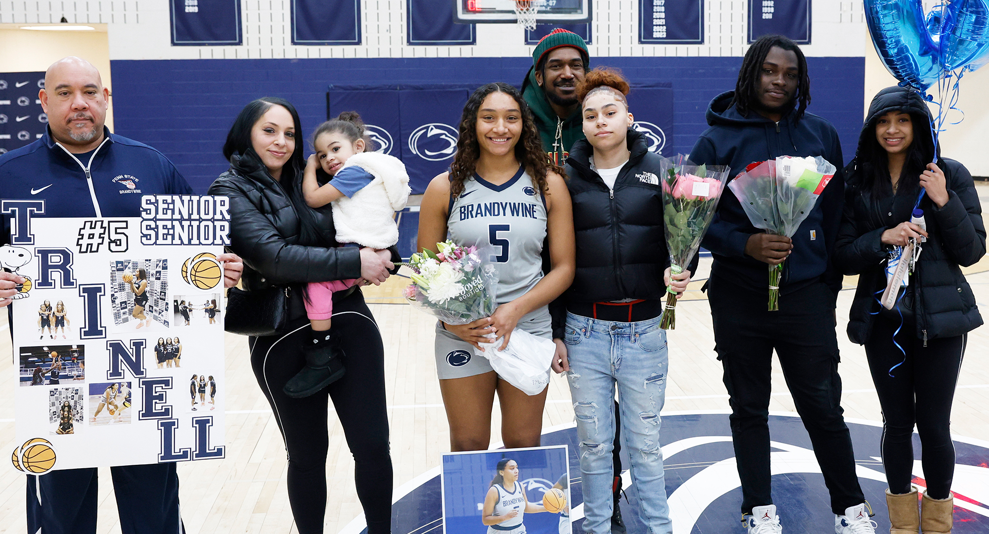 Senior Trinell Watson with family and coach Larry Johnson on Senior Day